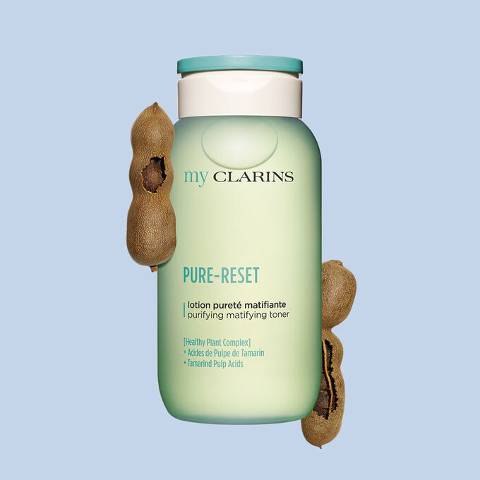 Packshot of a purifying and matifying facial lotion alongside tamarind beans on a light blue background